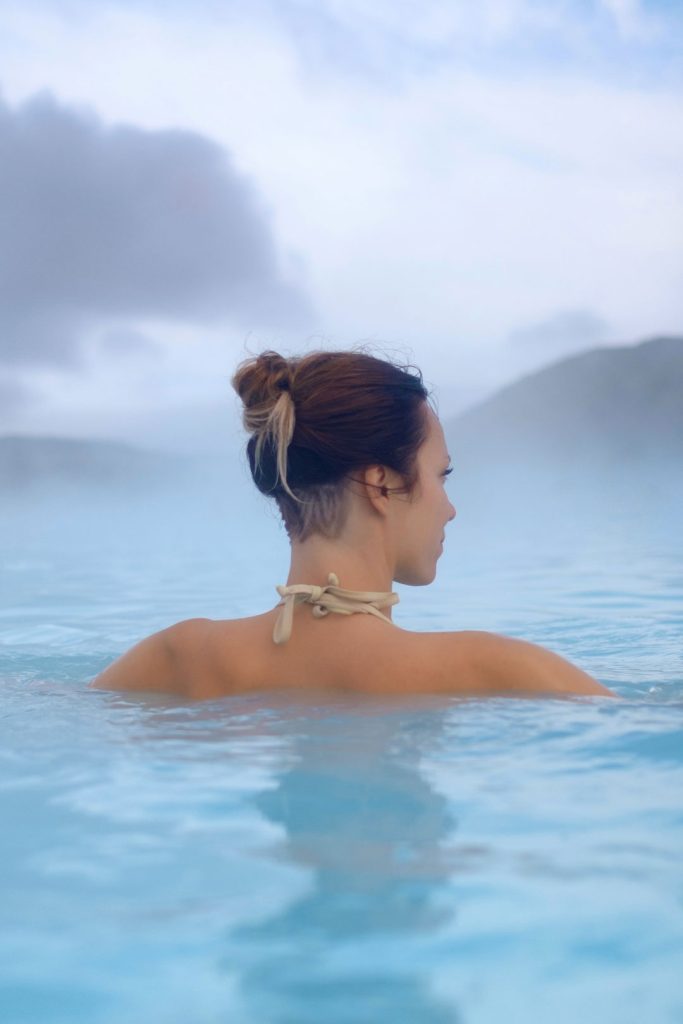 Woman standing in the middle of a hot spring.